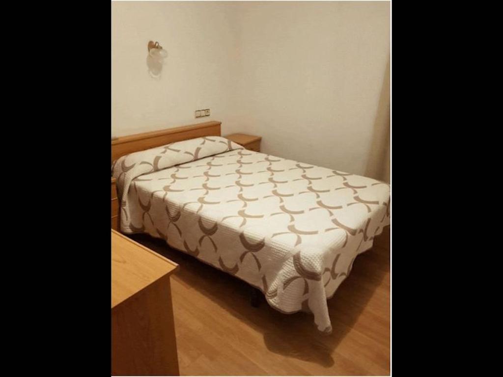 Schlafzimmer mit einem Bett und einem Holztisch in der Unterkunft Room in Lodge - Double and single room - Pension Oria 1 in Luarca