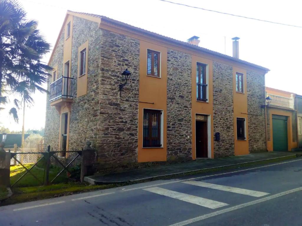 un edificio de ladrillo al lado de una calle en 4 bedrooms villa with private pool enclosed garden and wifi at Empalme de Vilar en Vilar