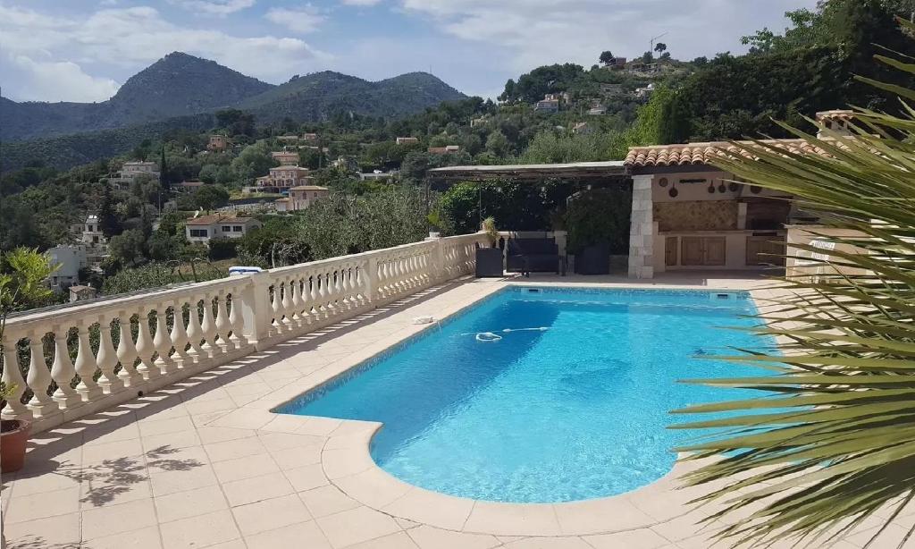 - une piscine sur une terrasse avec des montagnes en arrière-plan dans l'établissement Appartement Les Oliviers, à Saint-André