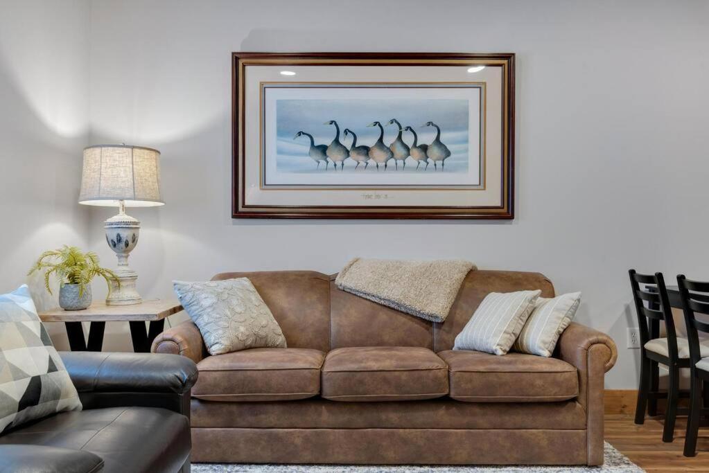 a living room with a couch and a picture of birds at Hickory Suite - Main Street Lodge in Berlin in Berlin