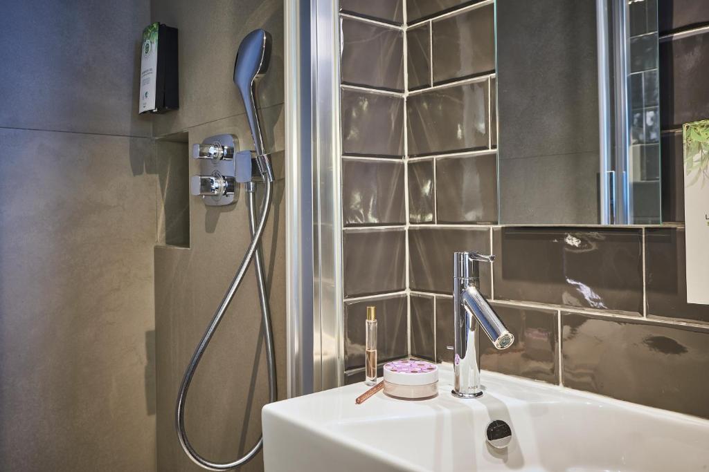 La salle de bains est pourvue d&#39;un lavabo et d&#39;une douche. dans l&#39;établissement Hotel Campanile Paris-Bercy Village, à Paris