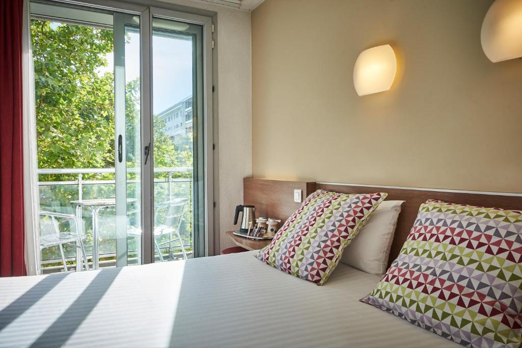 - une chambre avec un lit et une grande fenêtre dans l&#39;établissement Hotel Campanile Paris-Bercy Village, à Paris