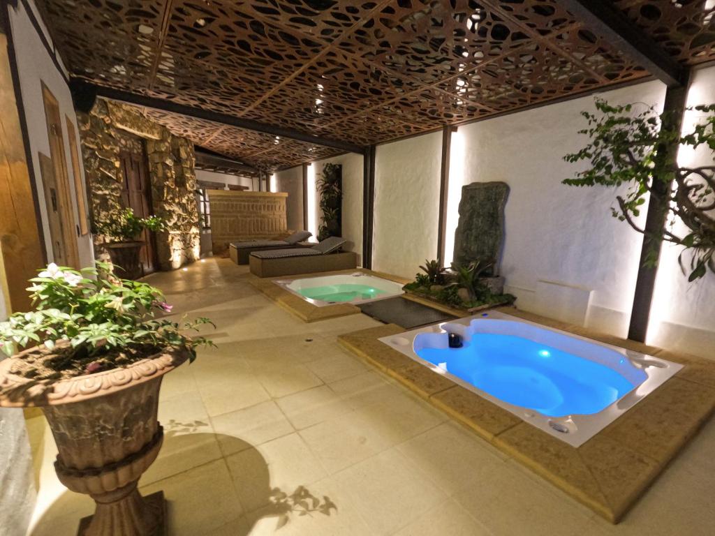 Habitación con baño grande con bañera azul grande. en Hotel Boutique El Carmel, en Villa de Leyva