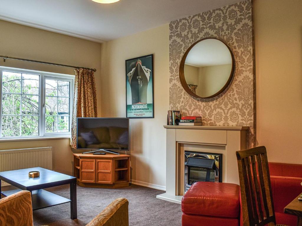 a living room with a tv and a fireplace at 8 Lowther Gardens in Grange Over Sands