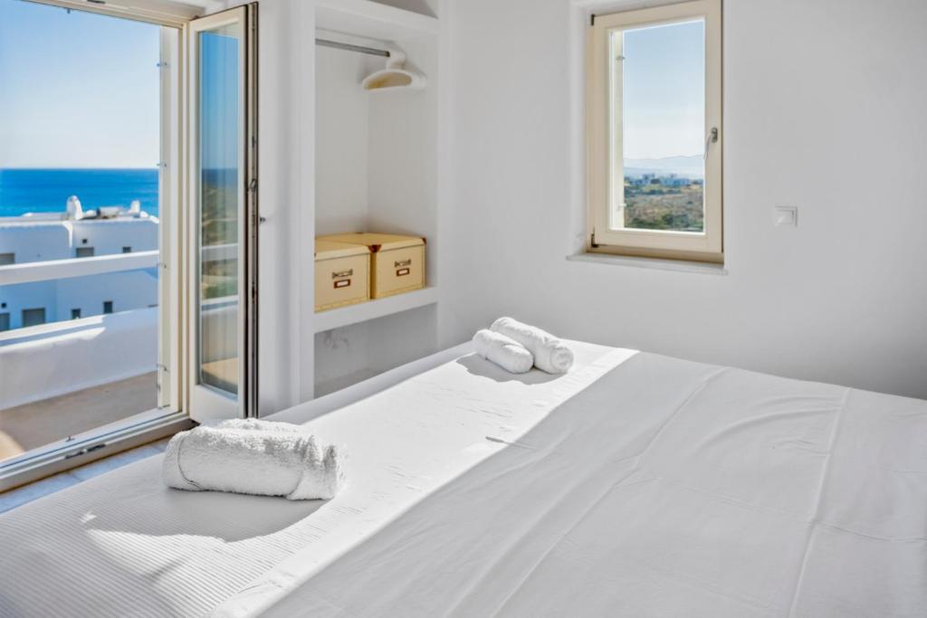 a white bedroom with a bed with a view of the ocean at Studio with Seaview at Faragas in Angairiá