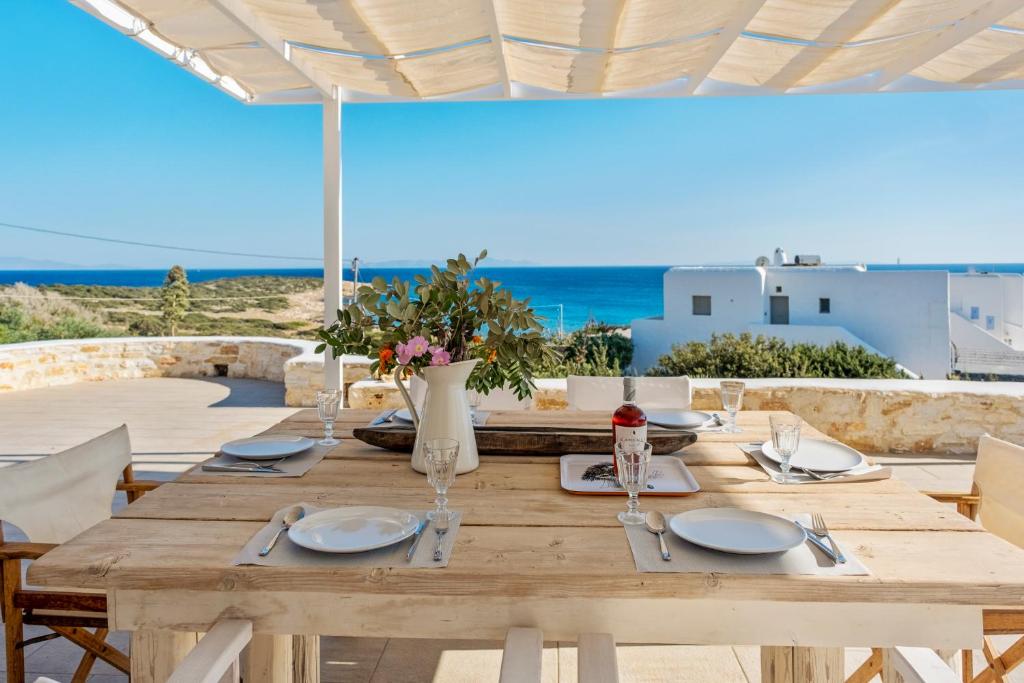 a wooden table with a view of the ocean at Scenic Seaview villa Iris at Faragas in Angairiá