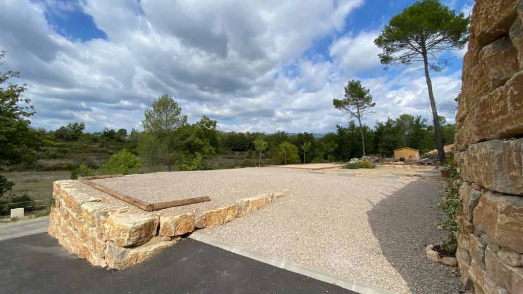 a stone bench sitting on the side of a road at LES ROCHES DE BAUDISSET in Saint-Paul-en-Forêt