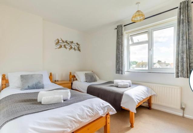 a bedroom with two beds and a window at Quayside in Wroxham