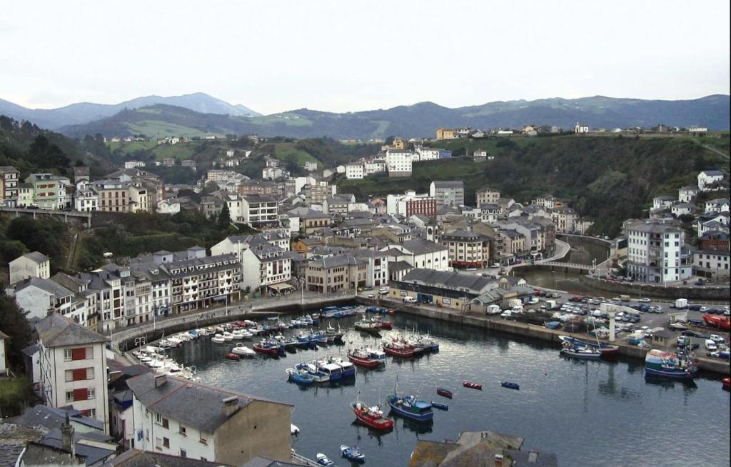 un groupe de bateaux dans un port d'une ville dans l'établissement Room in Lodge - Double and single room - Pension Oria 3, à Luarca