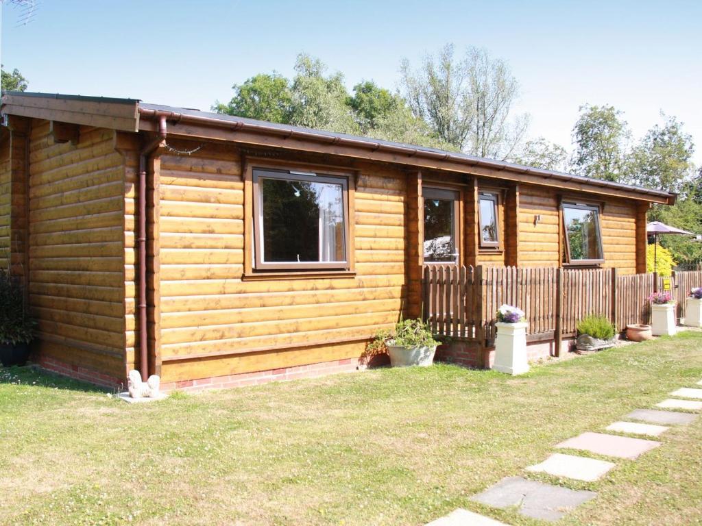 a log cabin with a fence in a yard at South Lodge in Great Moulton