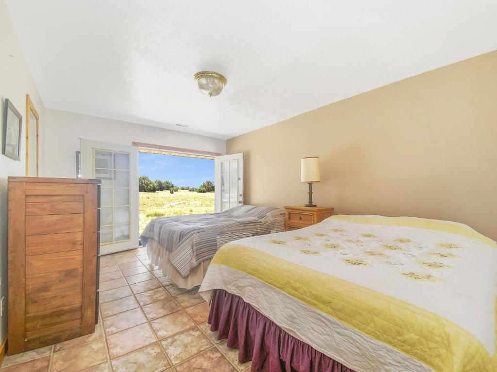 a bedroom with a bed and a window at Hacienda Roja - The Juniper #5 at Wind Walker Homestead in Spring City