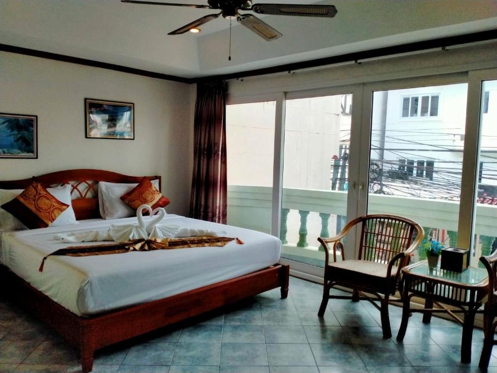 a bedroom with a bed and a large window at Orchid Residence in Patong Beach