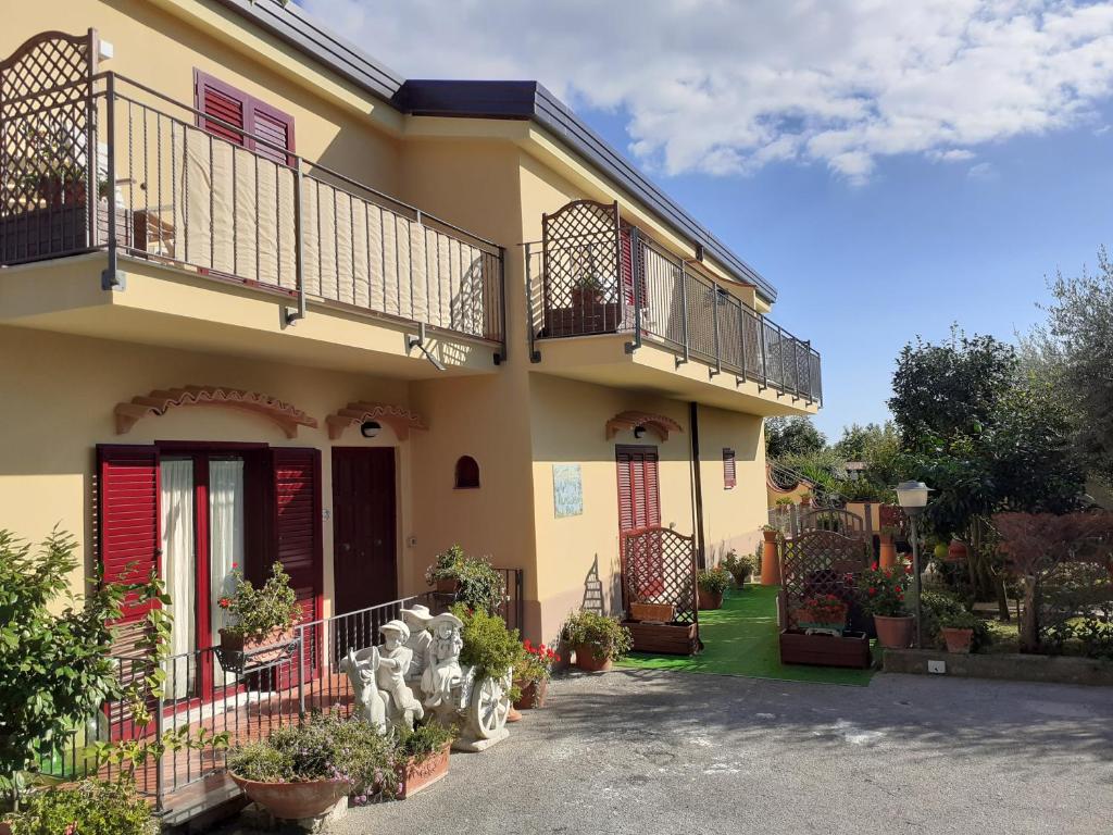 Casa amarilla con balcón y algunas plantas en Green Paradise Affittacamere, en SantʼAgata sui Due Golfi