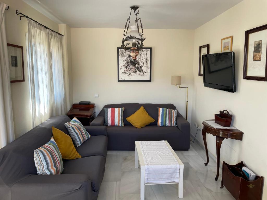 sala de estar con sofá azul y mesa en Atico Baviera Golf-Playa, en Caleta de Vélez