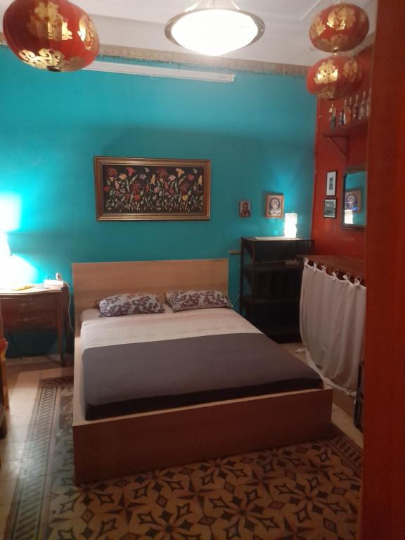 a bedroom with a bed and a blue wall at Micraasia Homtel in Athens
