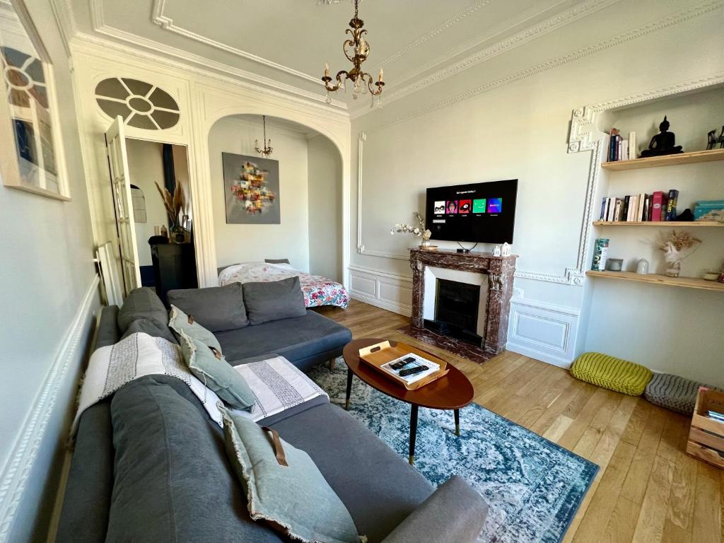 a living room with a couch and a fireplace at Le Téléphérique, vue Bastille, 6 pers, 300 m Gare in Grenoble