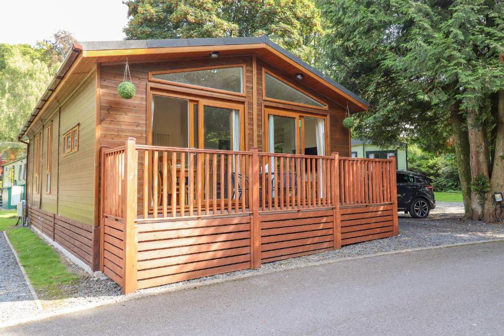 a small wooden cabin with a large window at Garuda in Windermere