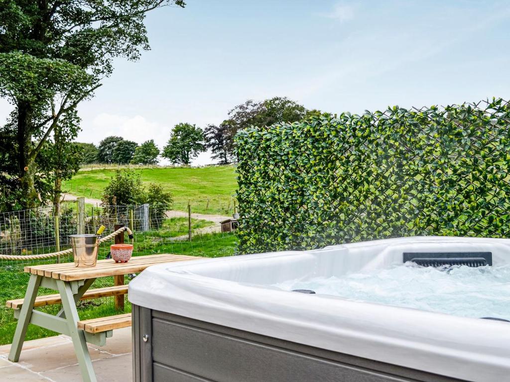 a bath tub in a garden with a fence at Cullew Bothy in Pearsie