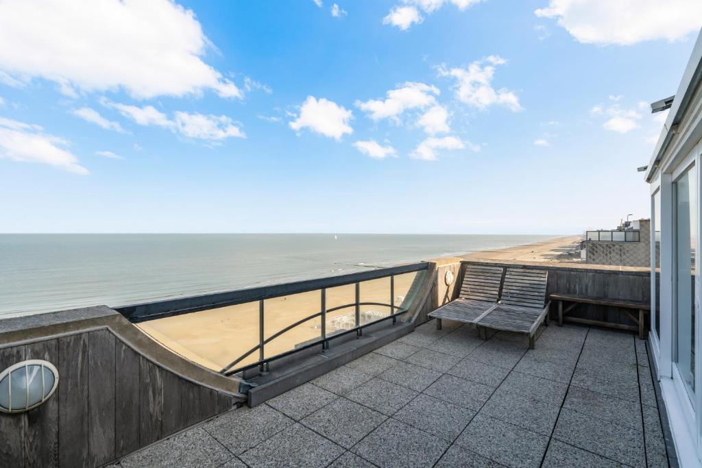 a balcony with a bench and a view of the ocean at Penthouse app met imposant & eindeloos zeezicht in Middelkerke