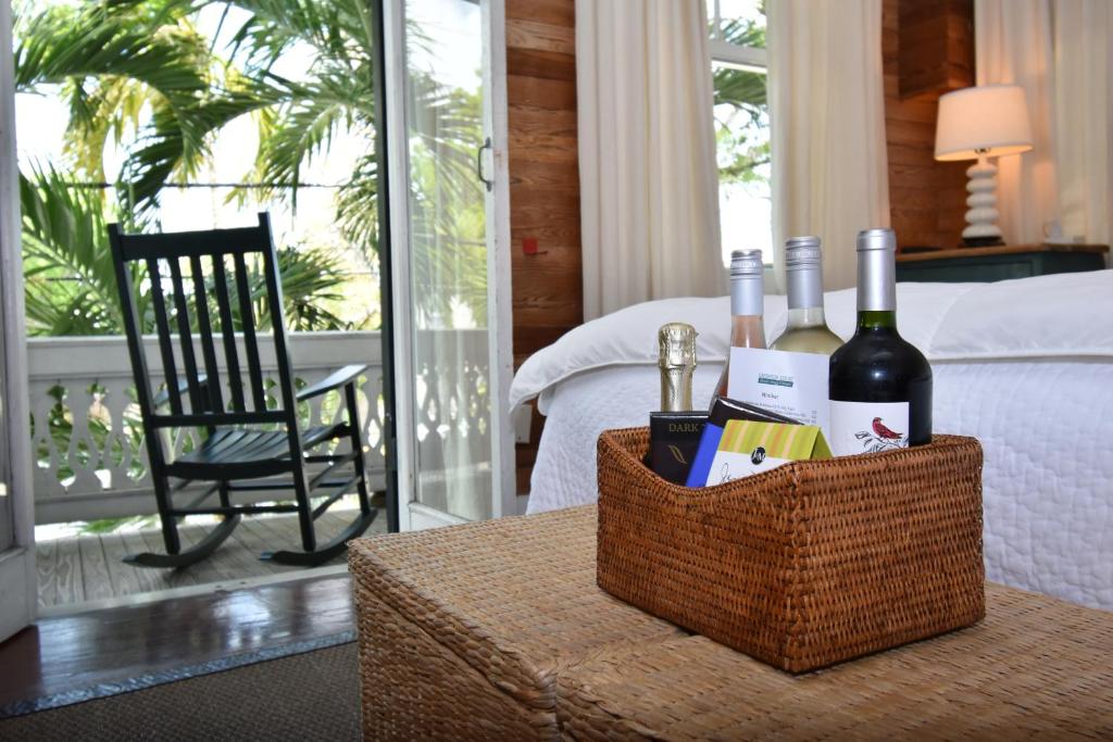 un cesto di vino su un tavolo accanto al letto di Simonton Court Historic Inn & Cottages a Key West