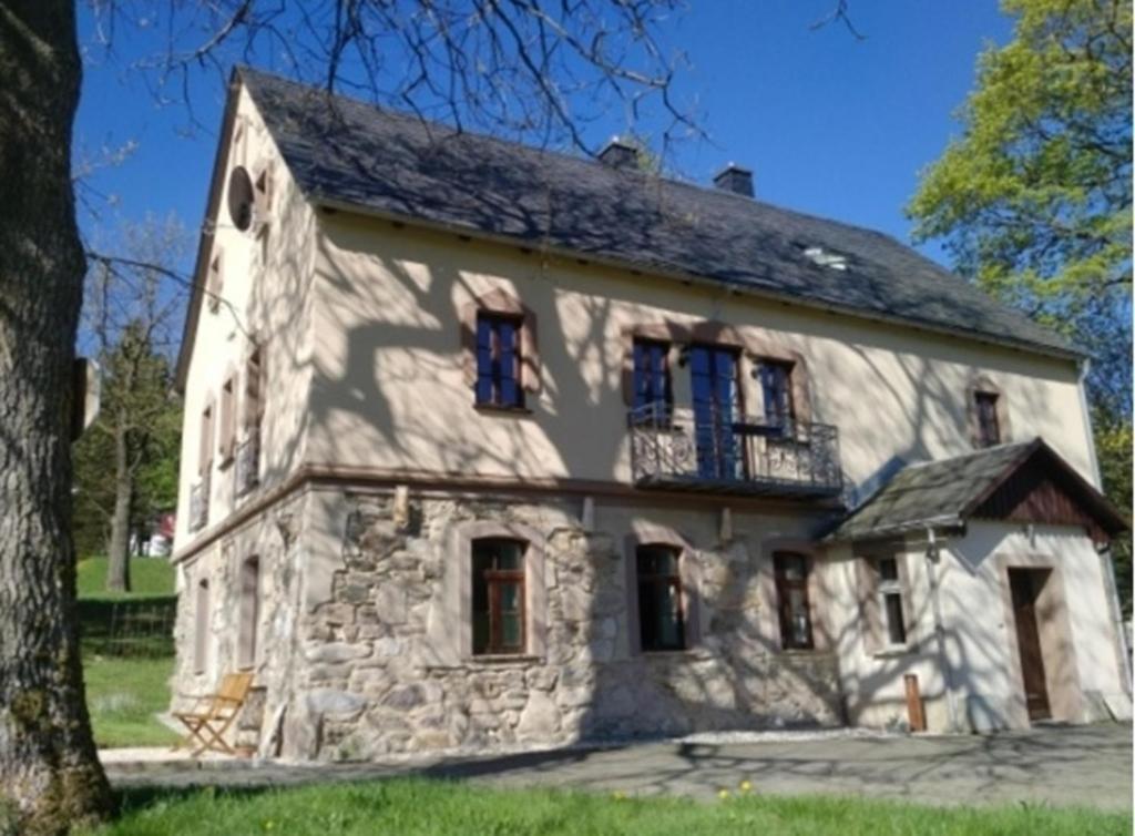 een oud stenen huis met een balkon bij Landhaus Sorgenfrey in Am Donnerberg