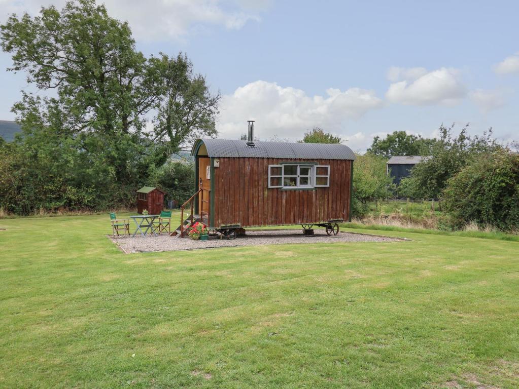 a tiny house sitting in a field of grass at Brown Hare Shepherds Hut in Brecon