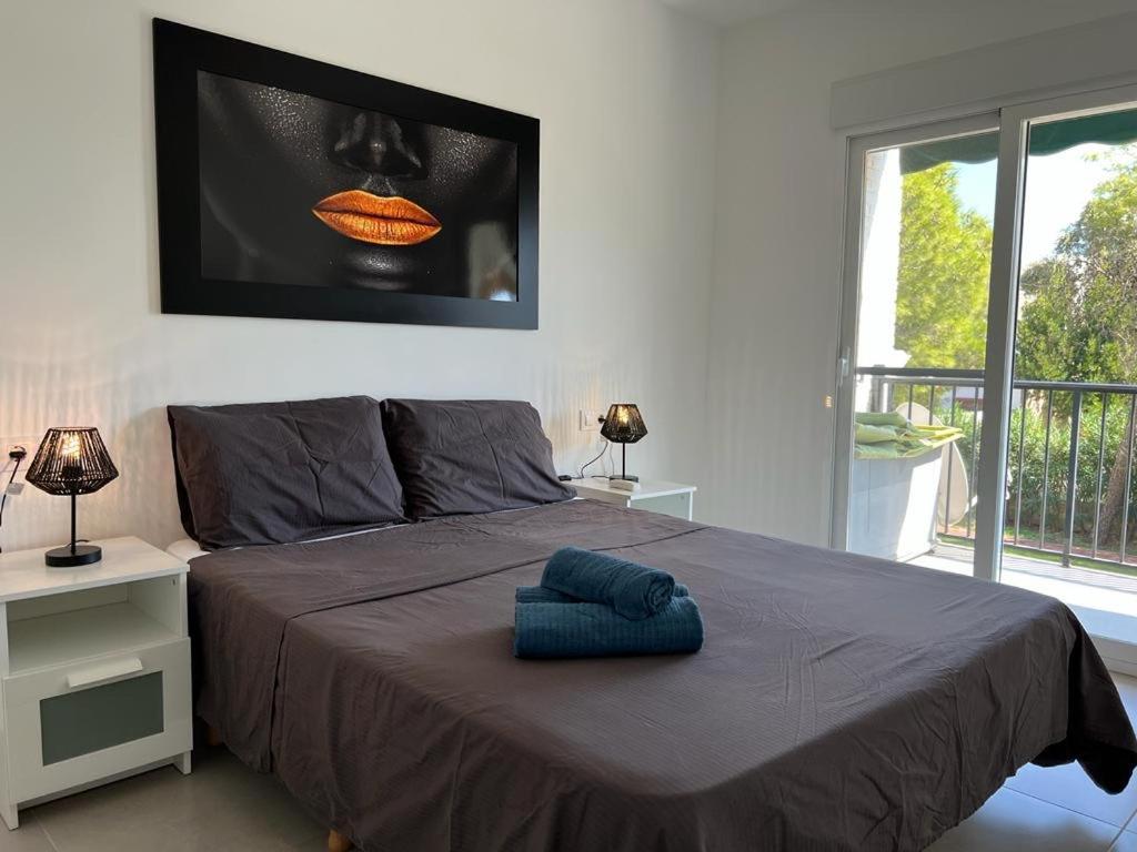 1 dormitorio con 1 cama grande y TV en la pared en Sunnybeach Apartment mit direktem Strandzugang, en Denia