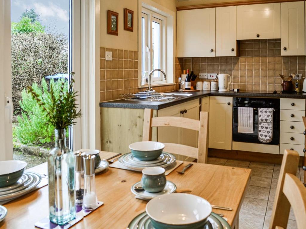 a kitchen with a wooden table with plates and bowls on it at Sinclairs in Gatehouse of Fleet