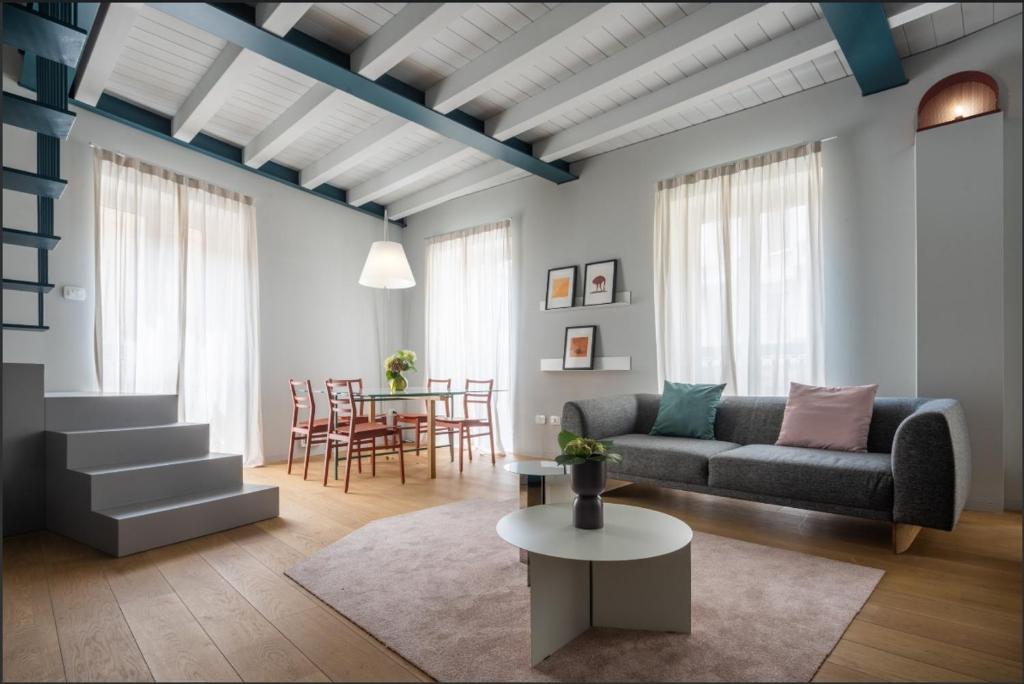 - un salon avec un canapé et une table dans l'établissement Heart Milan Apartments Porta Romana, à Milan