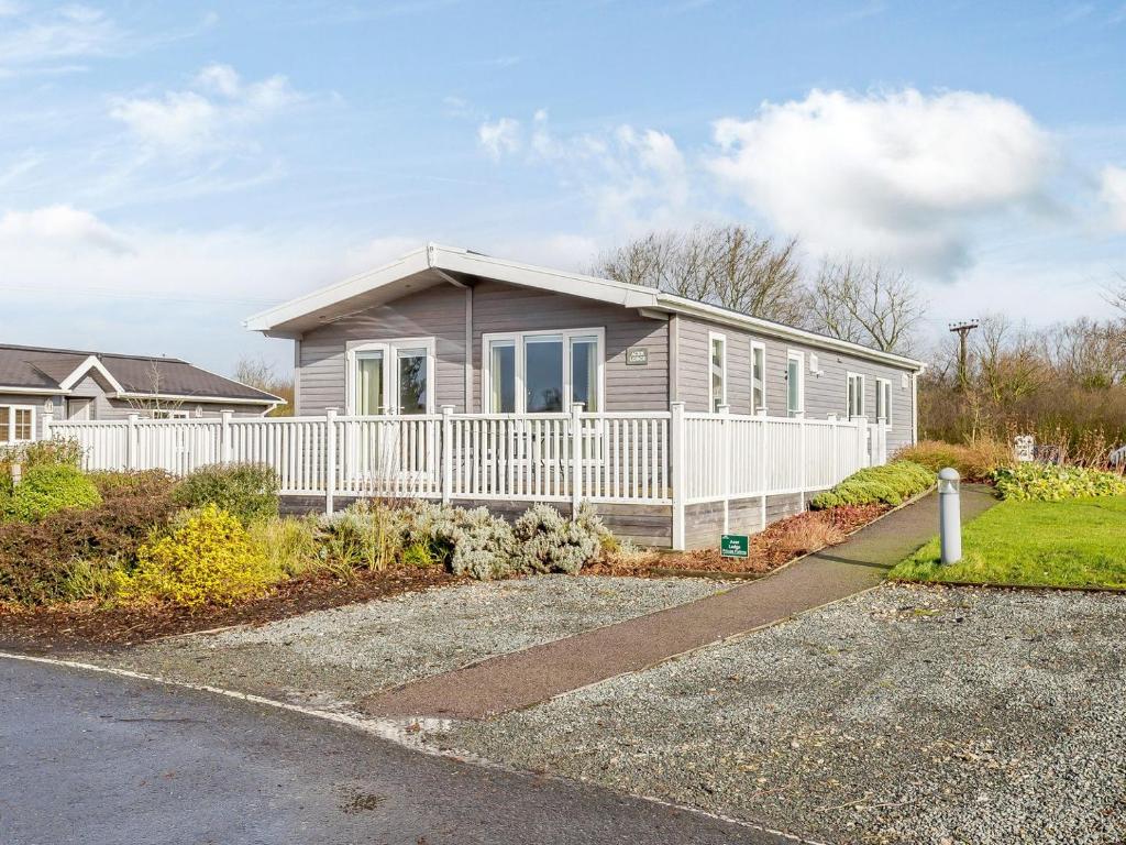 a house with a white fence in front of it at Acer Lodge-uk37594 in Willington