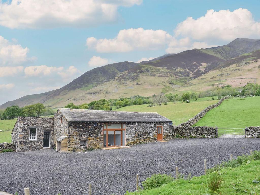 a stone house in a field with mountains in the background at Scaley Beck - Uk39151 in Threlkeld