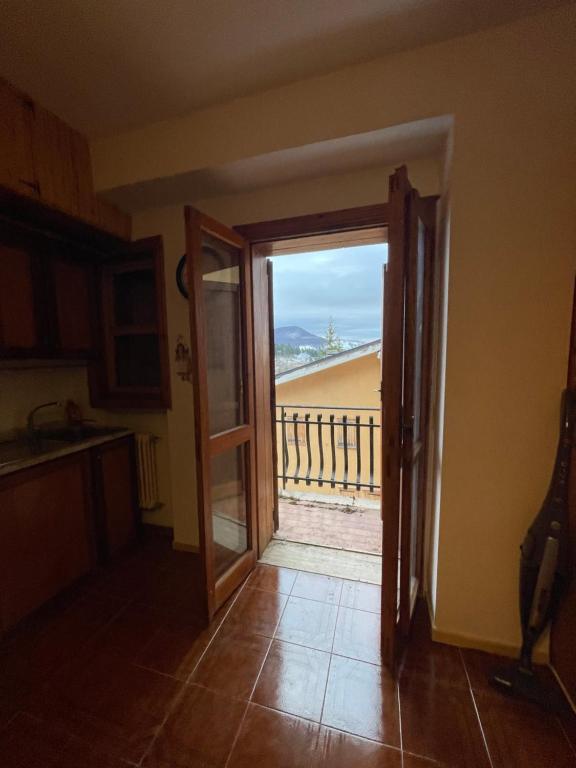 a kitchen with a door open to a balcony at Casetta Rivisondoli con Garage gratuito in Rivisondoli