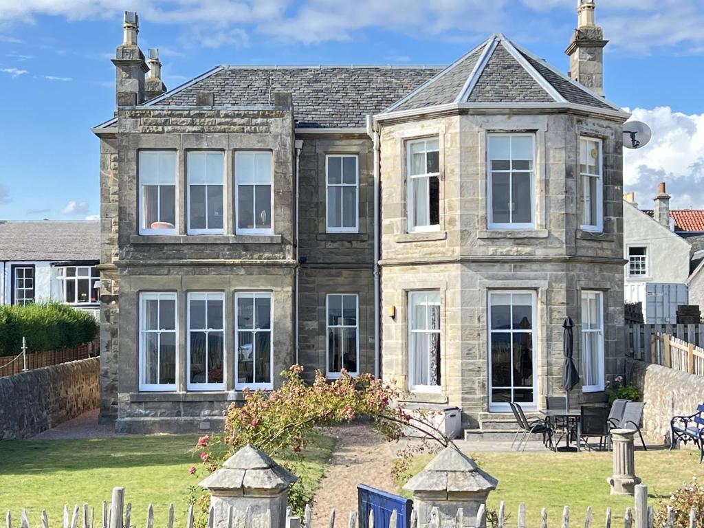 an old house with a fence in front of it at Ruddon Grange in Elie