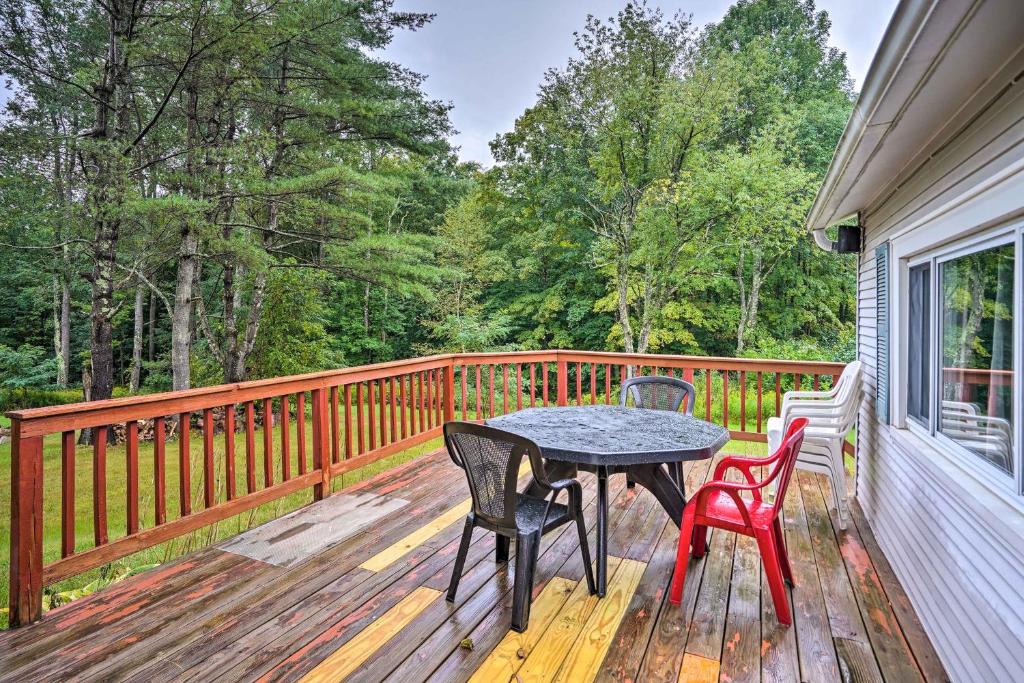 una terraza de madera con mesa y sillas. en Secluded Getaway Less Than 10 Mi to Saratoga Springs!, en South Corinth