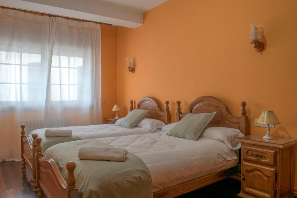 1 dormitorio con 2 camas individuales y ventana en Hostal Galicia, en Monforte de Lemos