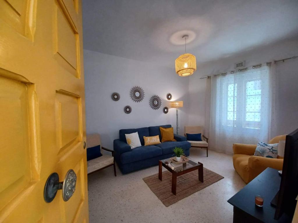 a living room with a blue couch and a table at Lucky Summer Marsalforn Holiday Apartment in Marsalforn