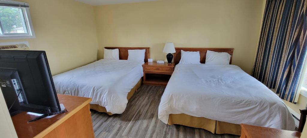 um quarto de hotel com duas camas e uma televisão de ecrã plano em North Shore Wayside Inn em Blind River