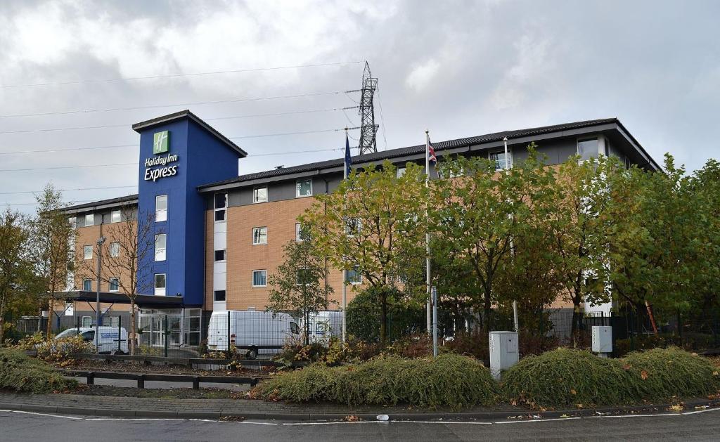 un hotel con un edificio azul delante de él en Holiday Inn Express Birmingham Star City, an IHG Hotel, en Birmingham