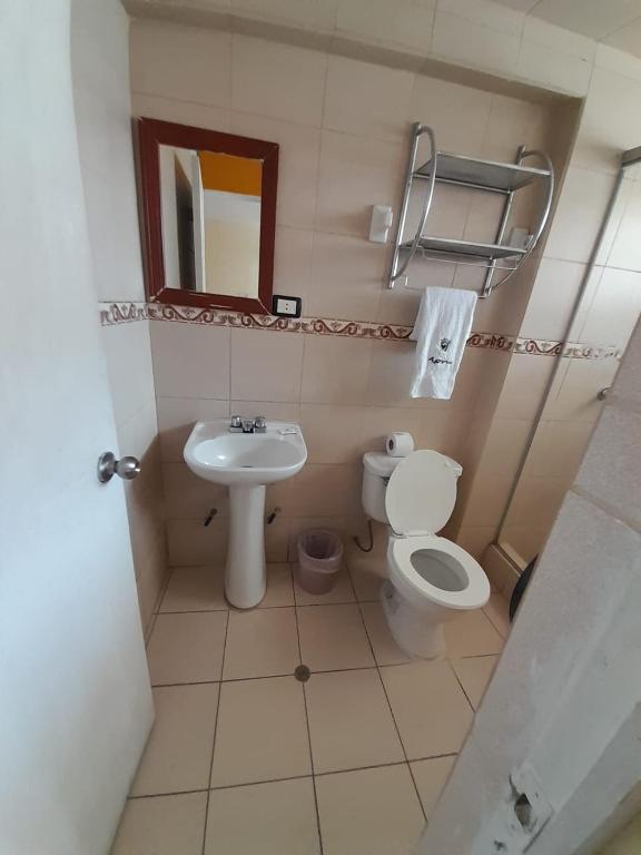 Un baño pequeño con inodoro y lavabo. en CasaHotel Centro - Huancayo, en Huancayo