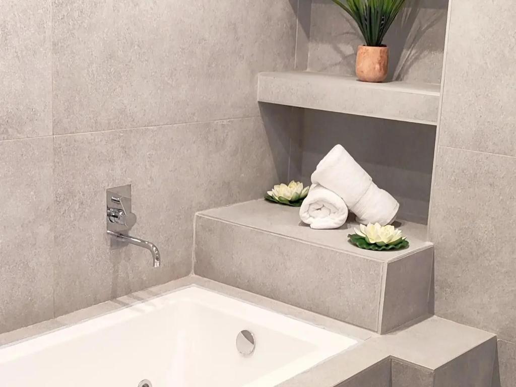 uma casa de banho com uma banheira e um lavatório com toalhas em Navarino Jacuzzi Studio RT Hospitality Services em Tessalônica