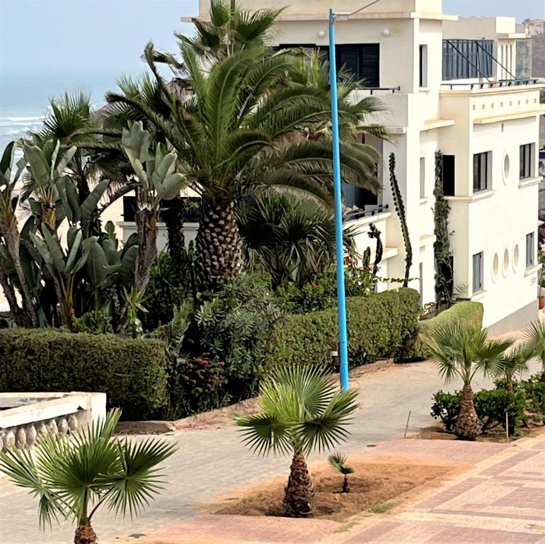 um pátio com palmeiras e um edifício em logis la marine em Sidi Ifni