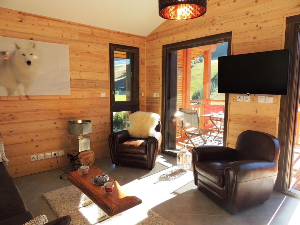 a living room with leather chairs and a flat screen tv at T3 aux Gets, vue sur pistes - FR-1-598-5 in Les Gets
