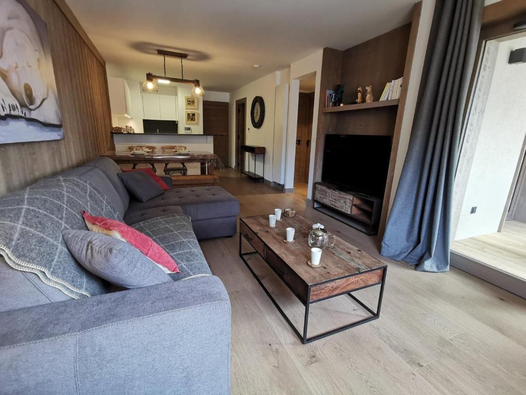 un salon avec un canapé et une table basse dans l'établissement Appartement neuf 54m² Les Gets, centre, balcon sud-ouest, Wifi, parking - FR-1-598-70, aux Gets