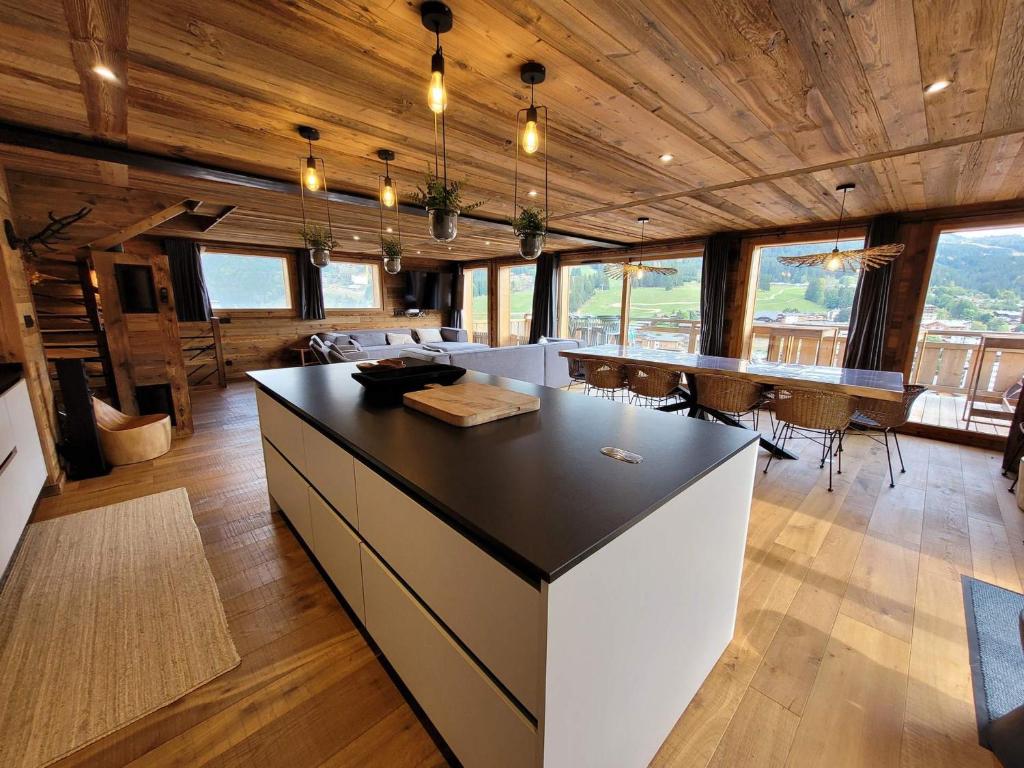 a kitchen with a large island in a room with windows at Chalet Les Gets, 5 pièces, 14 personnes - FR-1-598-19 in Les Gets