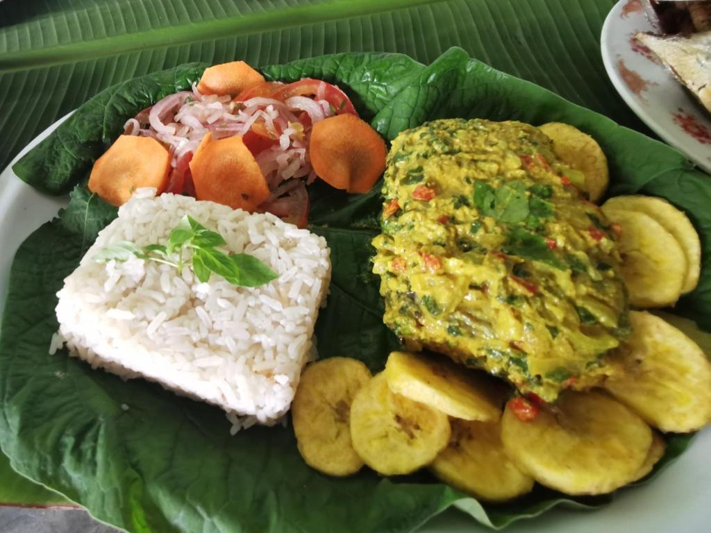 een bord met rijst en andere voedingsmiddelen bij Chowa lodge in Nuquí