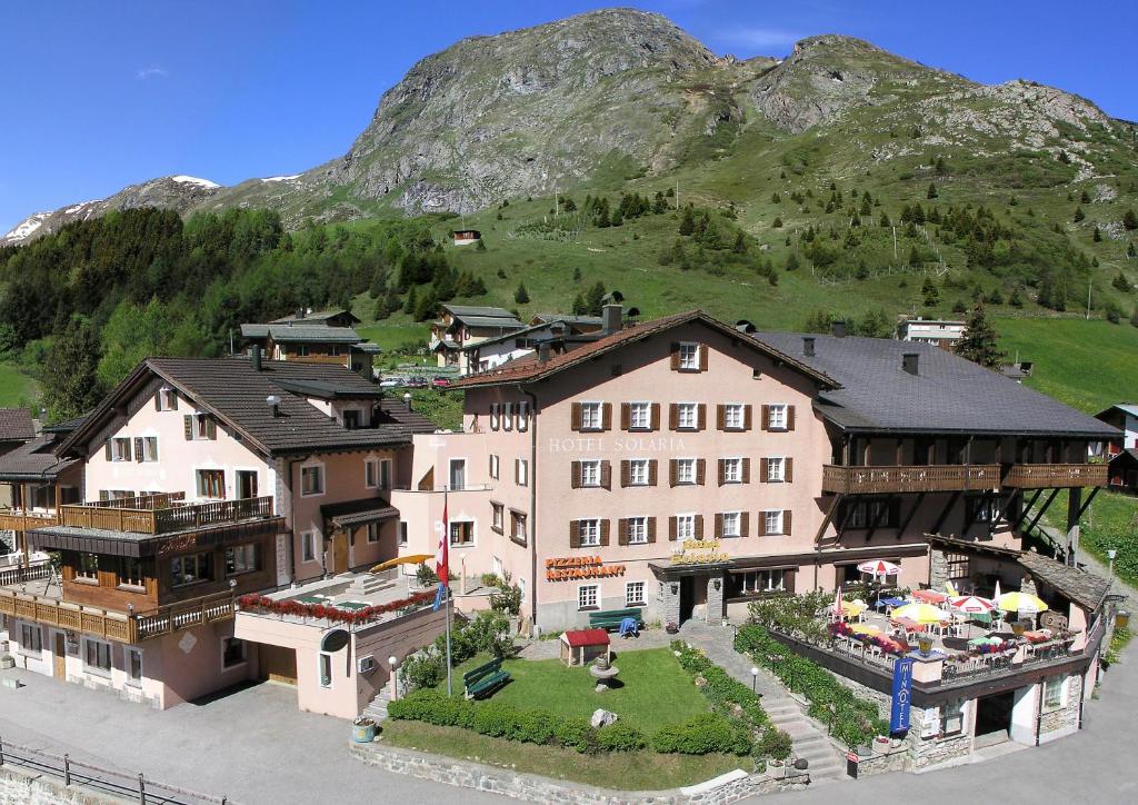 eine Gruppe von Gebäuden vor einem Berg in der Unterkunft Hotel Solaria in Bivio