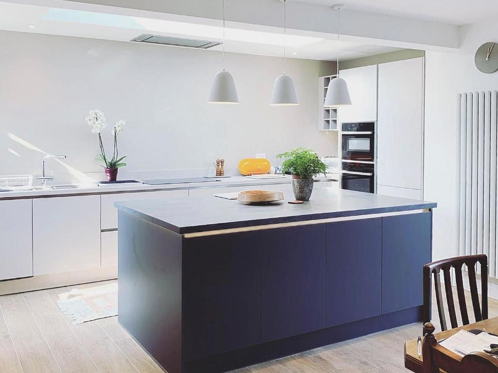 a kitchen with a blue island in the middle at Holland Beach Bungalow in Little Holland