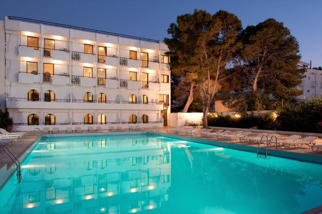 a hotel with a swimming pool in front of a building at Heronissos Hotel in Hersonissos