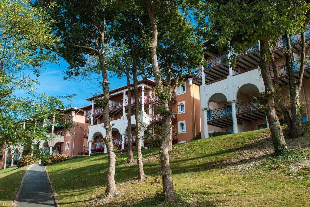 un bâtiment avec des arbres devant lui dans l'établissement Résidence Mer & Golf Soko-Eder, à Ciboure