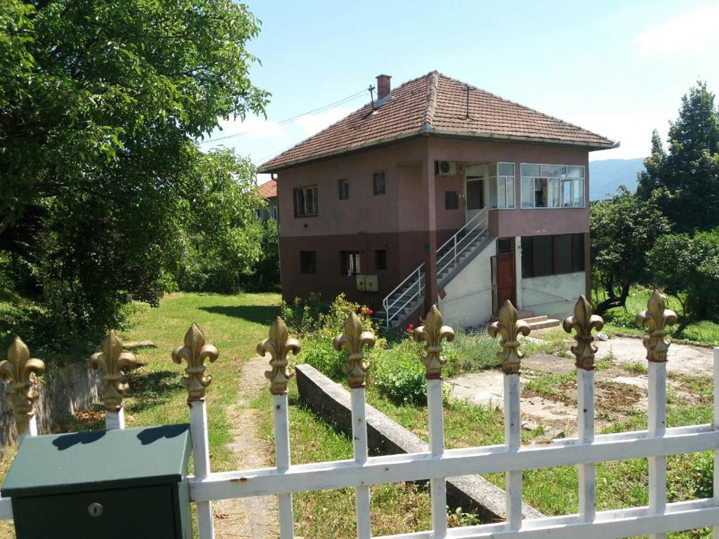 une maison derrière une clôture blanche avec un bâtiment dans l'établissement Kuća sa apartmanom, à Sarajevo